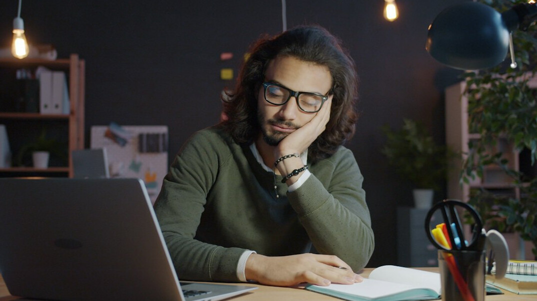 person studying at desk with laptop