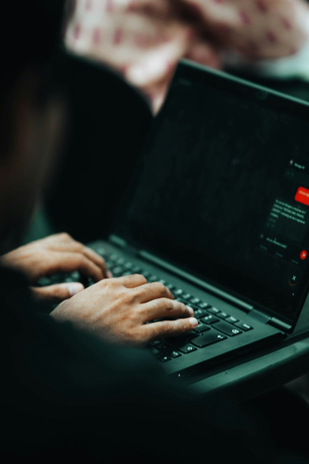 student coding on laptop in library