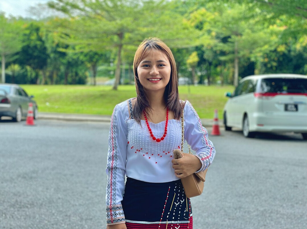Smiling Malaysian woman software developer giving a thumbs up